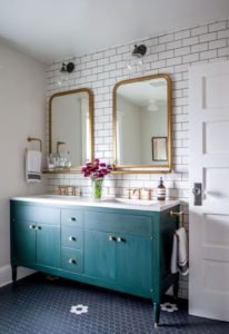 Eclectic bathroom with green cabinet